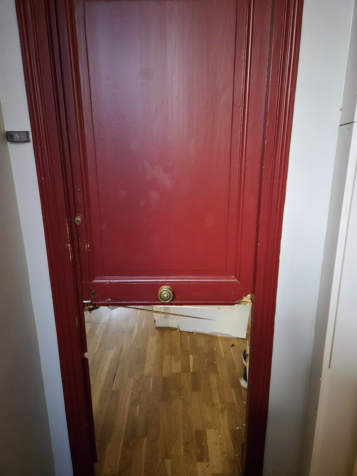 Porte d'entrée rouge au panneau inférieur fracturé